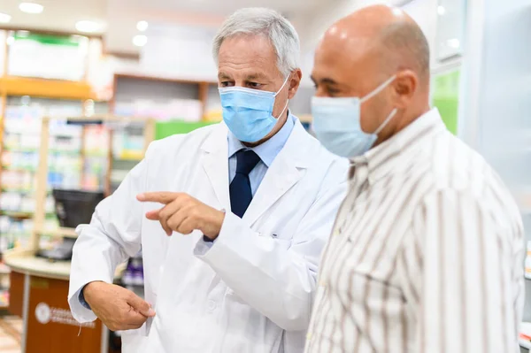 Farmacêutico Sênior Lidando Com Cliente Ambos Usando Máscaras Devido Coronavírus — Fotografia de Stock