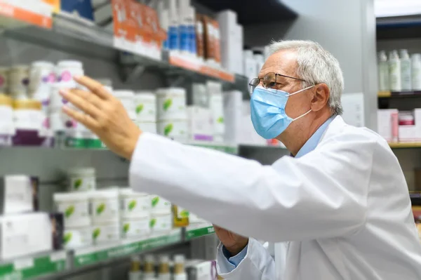 Farmacêutico Sênior Procura Produto Uma Prateleira Sua Loja Usando Uma — Fotografia de Stock