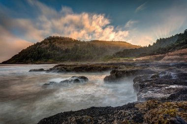 Çok doğal Cape Perpetua Oregon kıyılarında. Sahilde güneş doğarken çökmesini dalgaları uzun pozlama.