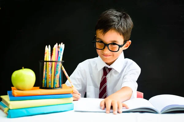 Smart preschool or first grade school boy in white shirt with eye glasses