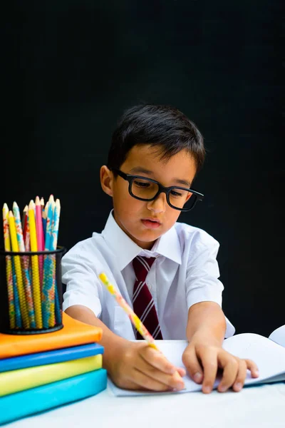 Smart preschool or first grade school boy in white shirt with eye glasses
