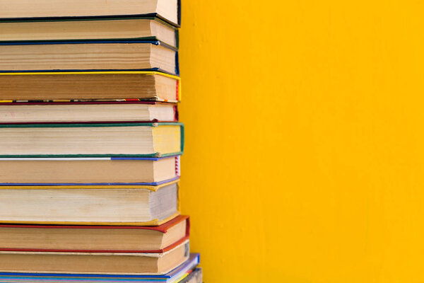 Stack of old books isolated on yellow background