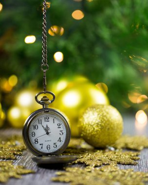 Arka planda noel süsleri olan saat 