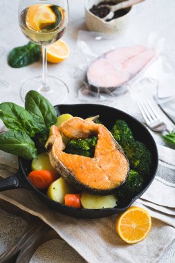 Izgara ya da kızarmış somon, sebzeli, yeşil ıspanak yaprağı brokoli, patates ve bir bardak beyaz şarapla birlikte havuç. Sağlıklı ev yapımı gıda konsepti, seçili odaklanma