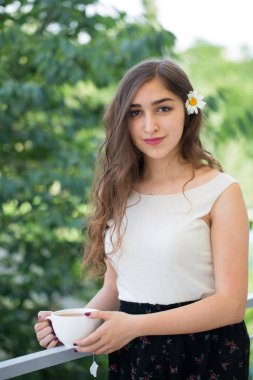 Bir fincan çayla genç ve güzel bir kadının portresini yakından çek. 