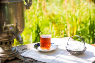 Altın renkli semaver ve çay bardağıyla güzel bir çay seti.