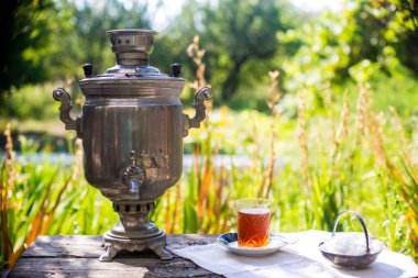 Altın renkli semaver ve çay bardağıyla güzel bir çay seti.
