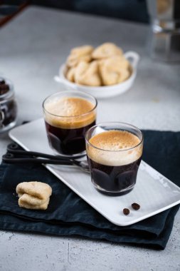 Süt kavanozu ve kahve makinesiyle beyaz dikdörtgen tepside iki fincan taze espresso seçici odak, fotokopi alanı, kahvaltı konsepti