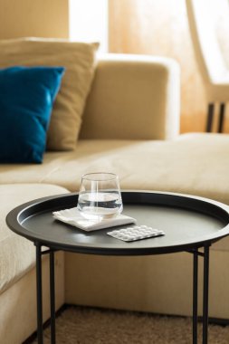 Masada bir bardak su ve hap var. 