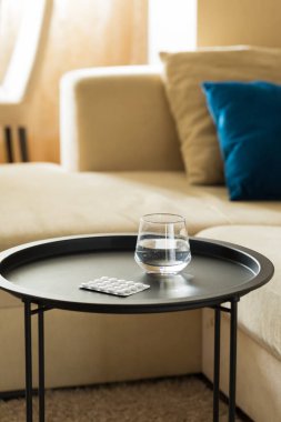 Masada bir bardak su ve hap var. 