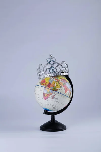 plastic globe with crown on blue background