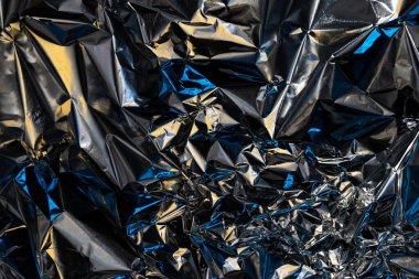 Kırışmış alüminyum gümüş yüzey, renkli neon ışık refleksi, soyut arkaplan