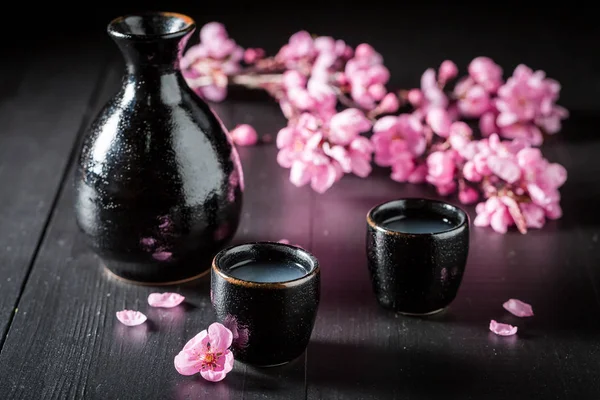 黑色陶瓷在黑色桌子上未经过滤的烈性清酒 — 图库照片