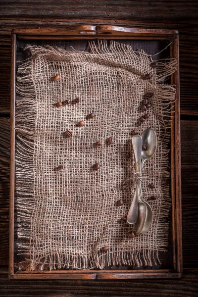 古いバーラップ ドイリーと素朴な木製トレイにコーヒー豆 — ストック写真