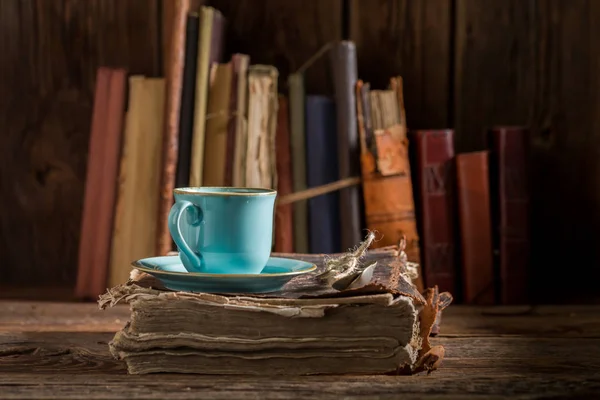 图书馆书籍上的蓝色瓷器中的乡村咖啡 — 图库照片