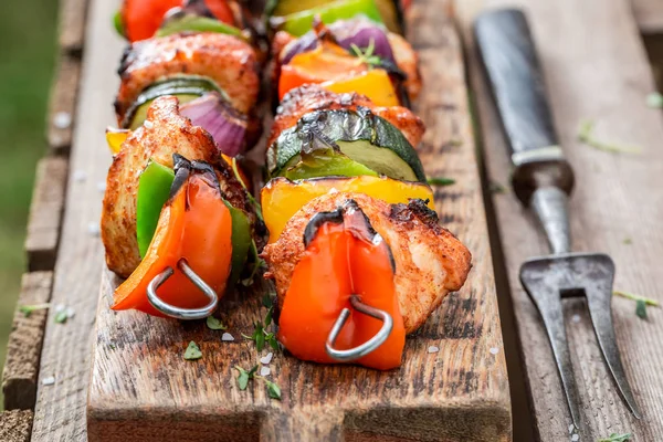 Sabrosos pinchos a la parrilla servidos con agua en el jardín de verano — Foto de Stock