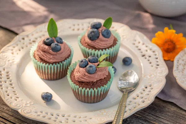 Delicious brown cupcake served with coffee in garden — Stock Photo, Image