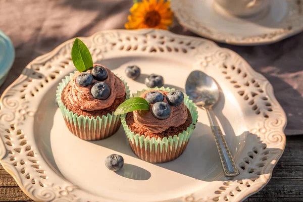 Chocolate muffin with fresh blueberries and cream on plate — Stock Photo, Image