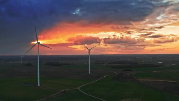 Wspaniały widok z lotu ptaka turbin wiatrowych na pole z o zachodzie słońca — Wideo stockowe