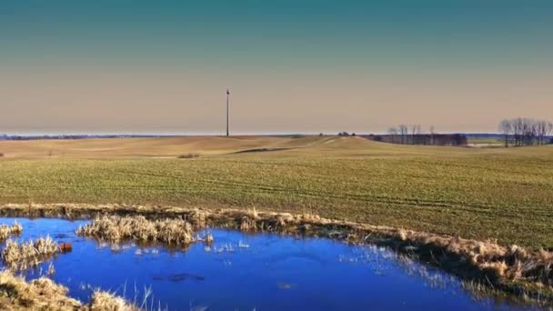 Windkraftanlage und kleiner blauer Teich bei sonnigem Wetter, Luftaufnahme — Stockvideo