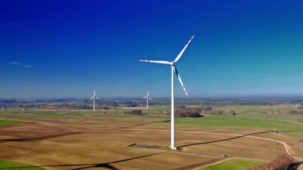 Flygfoto över vita vindkraftverk med blå himmel på bruna fält — Stockvideo