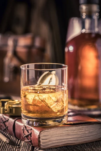 Gold whisky with ice on old journal — Stock Photo, Image