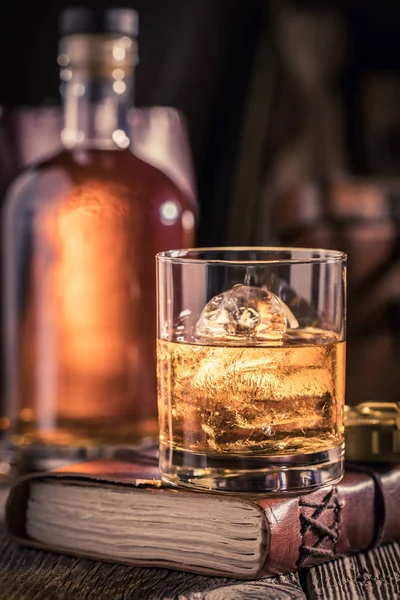 Szklankę whisky z lodem na stare czasopisma — Zdjęcie stockowe