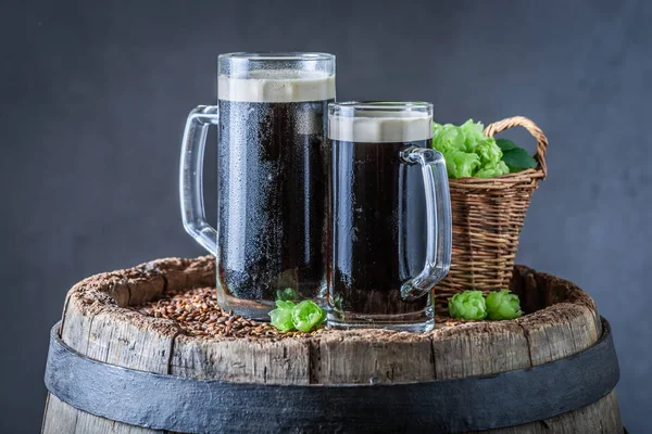 Two pint of dark beer with wheat and hops — Stock Photo, Image