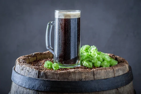 Холодная пинта тёмного пива на старой деревянной бочке — стоковое фото