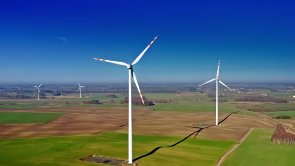 Ветряные турбины с голубым небом на фермерском поле, вид с воздуха — стоковое видео