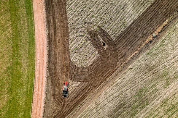 Rode trekker ploegen veld op voorjaar, uitzicht vanaf drone — Stockfoto