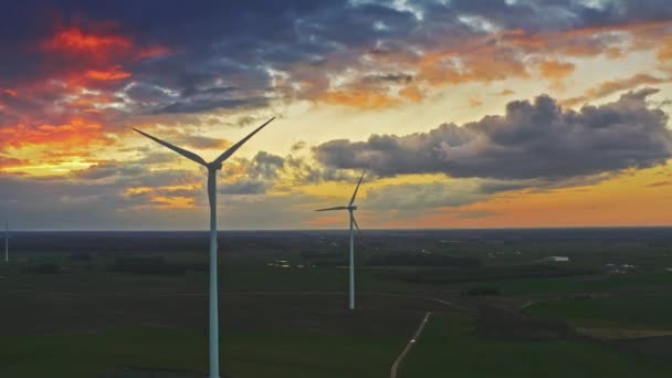 Atemberaubende Luftaufnahme des Sonnenuntergangs mit Windrädern auf dem Feld — Stockvideo