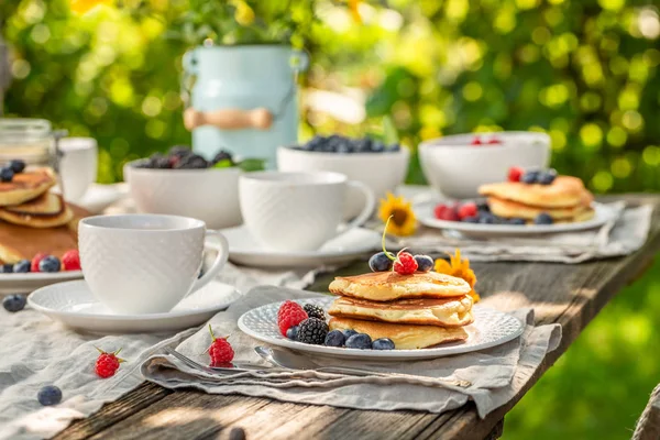 Leckere Pfannkuchen serviert mit Kaffee im Garten — Stockfoto