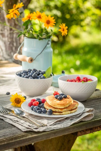 Süße Pfannkuchen zum Frühstück im sonnigen Garten — Stockfoto