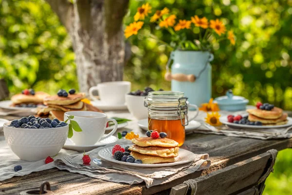 Hausgemachte Pfannkuchen zum Frühstück im sonnigen Garten — Stockfoto