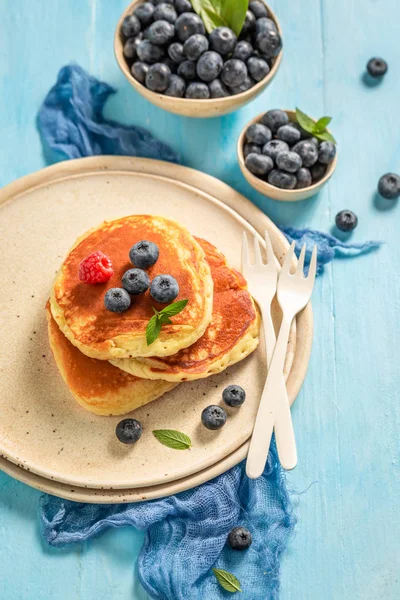 Maukkaita amerikkalaisia pannukakkuja aamiaiseksi sinisellä pöydällä — kuvapankkivalokuva