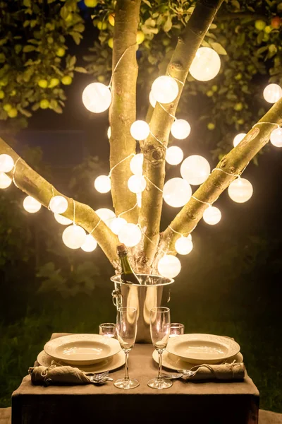 Illuminated table for two with champagne and glasses — Stock Photo, Image