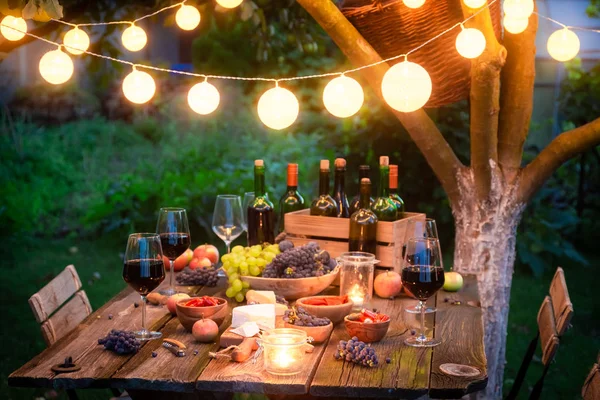 Rustic table with cheese, red wine in the evening — Stock Photo, Image