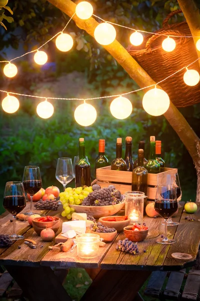 Rustikt bord med vin och frukt på kvällen — Stockfoto