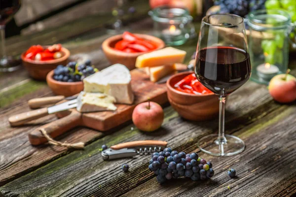 Preparação para jantar com aperitivos e vinho em jardim iluminado — Fotografia de Stock