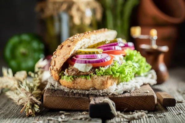 Sanduíche delicioso com pescoço de porco assado, pepinos e cebola — Fotografia de Stock