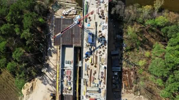 Luftaufnahme einer Autobahnbaustelle, Bau einer Brücke über den Fluss — Stockvideo