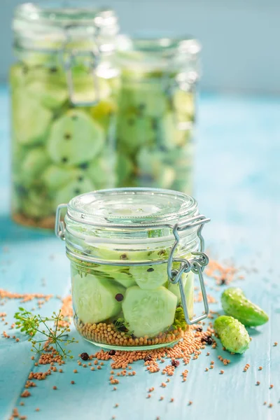 Pepino enlatado caseiro no frasco na mesa azul — Fotografia de Stock