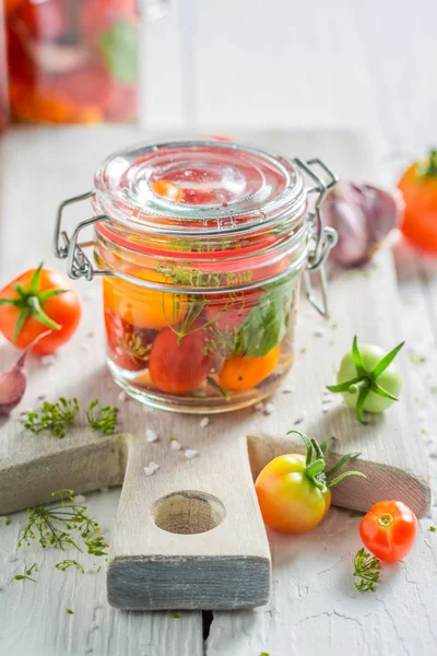 Естественные и здоровые консервированные красные помидоры на деревянном столе — стоковое фото