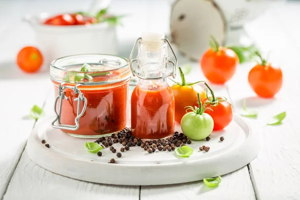 Rode en pittige ketchup gemaakt van tomaten op witte tafel — Stockfoto