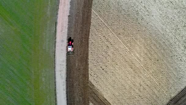 Aerial view of red tractor plowing a spring field in Poland — Stock Video