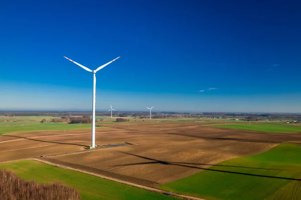 棕色田野和蓝天中的白色大风力涡轮机 — 图库照片