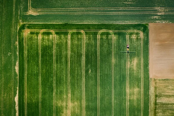 Kis traktor permetezés a növényvédő szerek a pályán, légi nézet — Stock Fotó