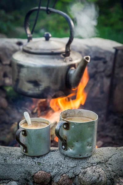 Café chaud sur rochers avec bouilloire sur feu de camp — Photo
