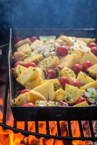 Batatas assadas na grelha com alho e alecrim na fogueira — Fotografia de Stock